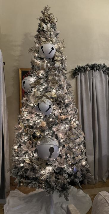A tall flocked tree with champagne ribbon